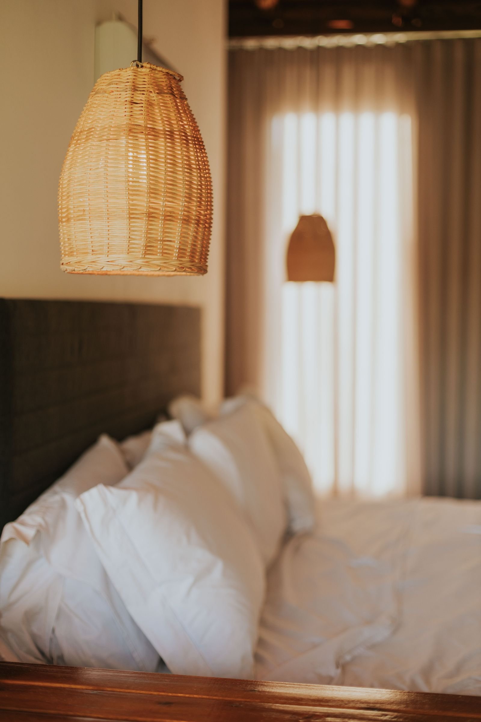 Serene bedroom styled with a woven lampshade and soft neutral bedding